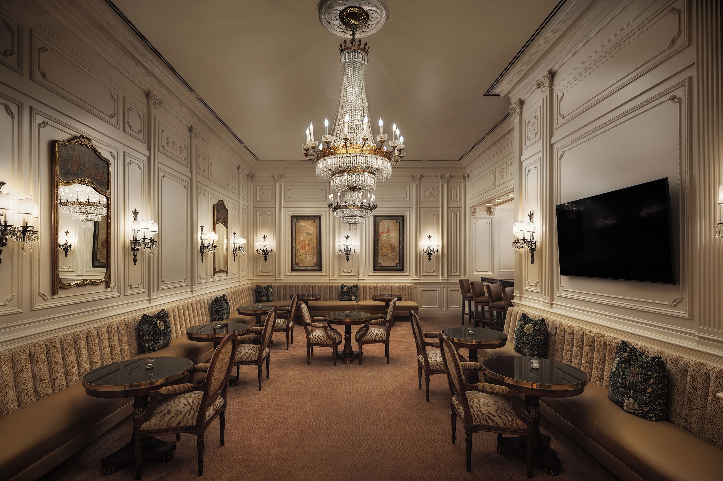 A formal dining room with a chandelier, multiple tables, and chairs.