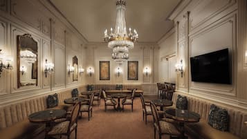 A formal dining room with a chandelier, multiple tables, and chairs.