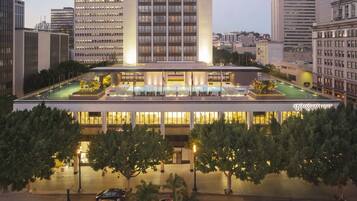 A hotel with a rooftop pool, multiple floors, and a well-lit facade.