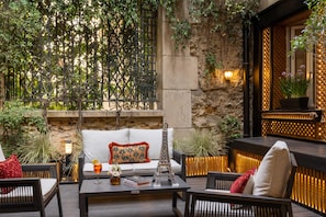 Un espace extérieur aménagé avec un canapé, des chaises, une table et des éléments de décoration.