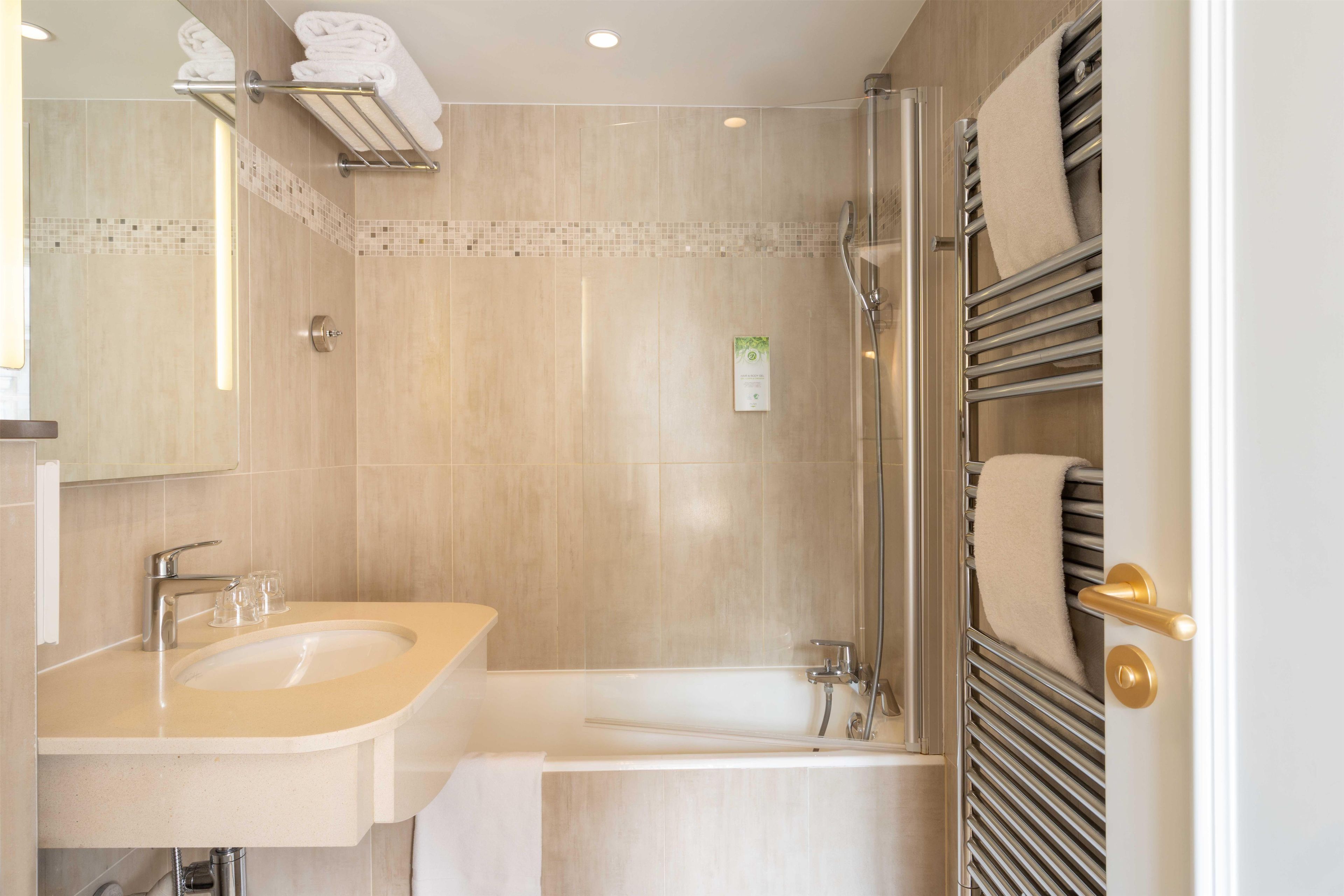 Ein modernes Badezimmer mit Waschbecken, Spiegel und Dusche.