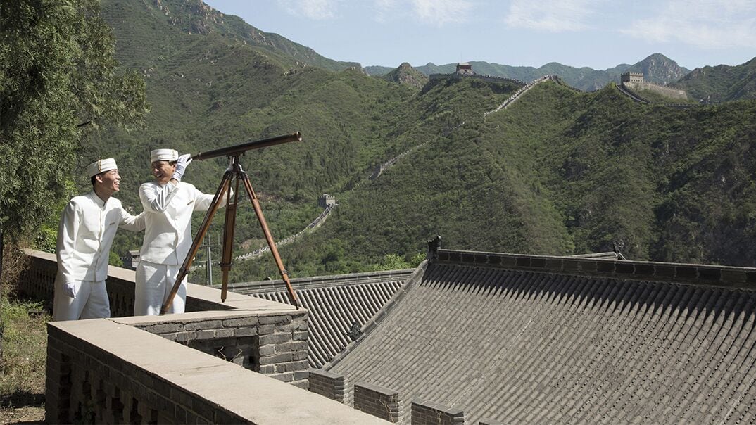 A traditional Chinese architectural structure with a tiled roof and a stone wall.