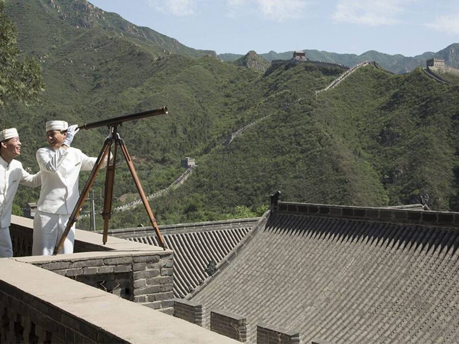 A traditional Chinese architectural structure with a tiled roof and a stone wall.