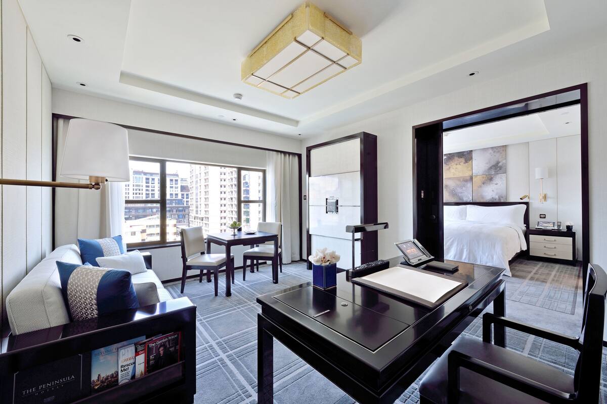 Habitación de hotel moderna con sofá, escritorio, cama y vistas a la ciudad.