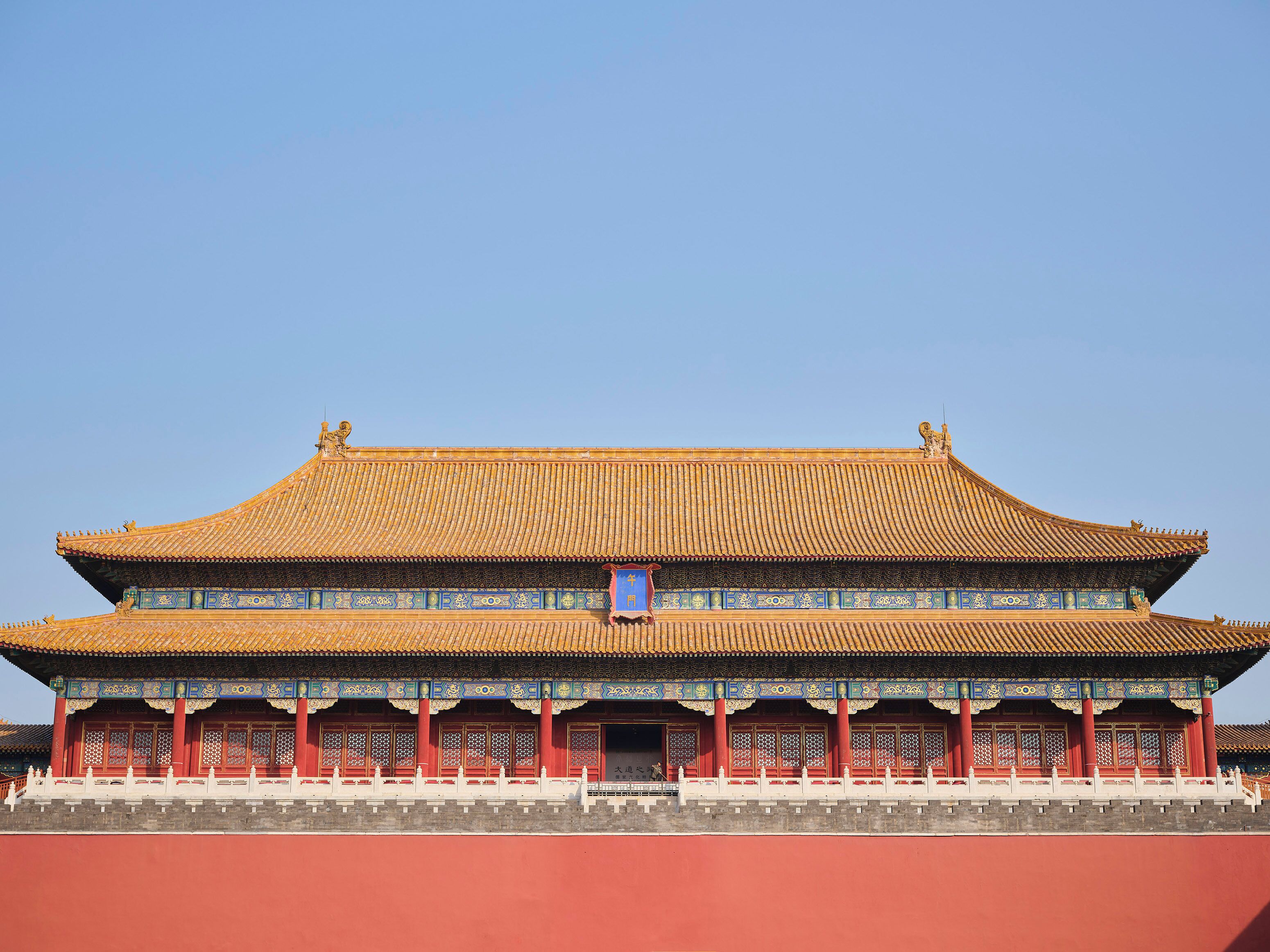 Un edificio tradicional chino con tejado de tejas, paredes rojas y motivos azules decorativos.