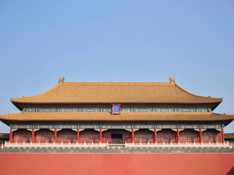 Un edificio tradicional chino con tejado de tejas, paredes rojas y motivos azules decorativos.