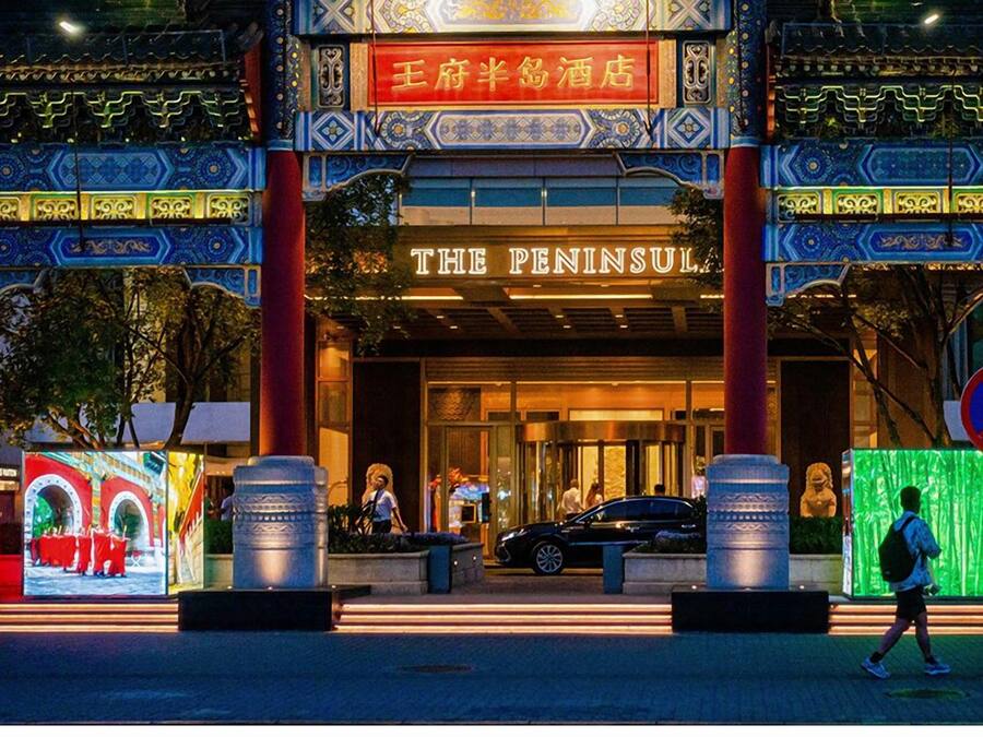 L’entrée de l’hôtel Peninsula, avec ses éléments architecturaux traditionnels chinois et une enseigne en chinois.