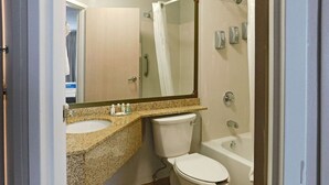 A bathroom with a granite countertop, a toilet, a bathtub, and a shower with a glass door. - Quality Inn Colchester - Burlington (Colchester)