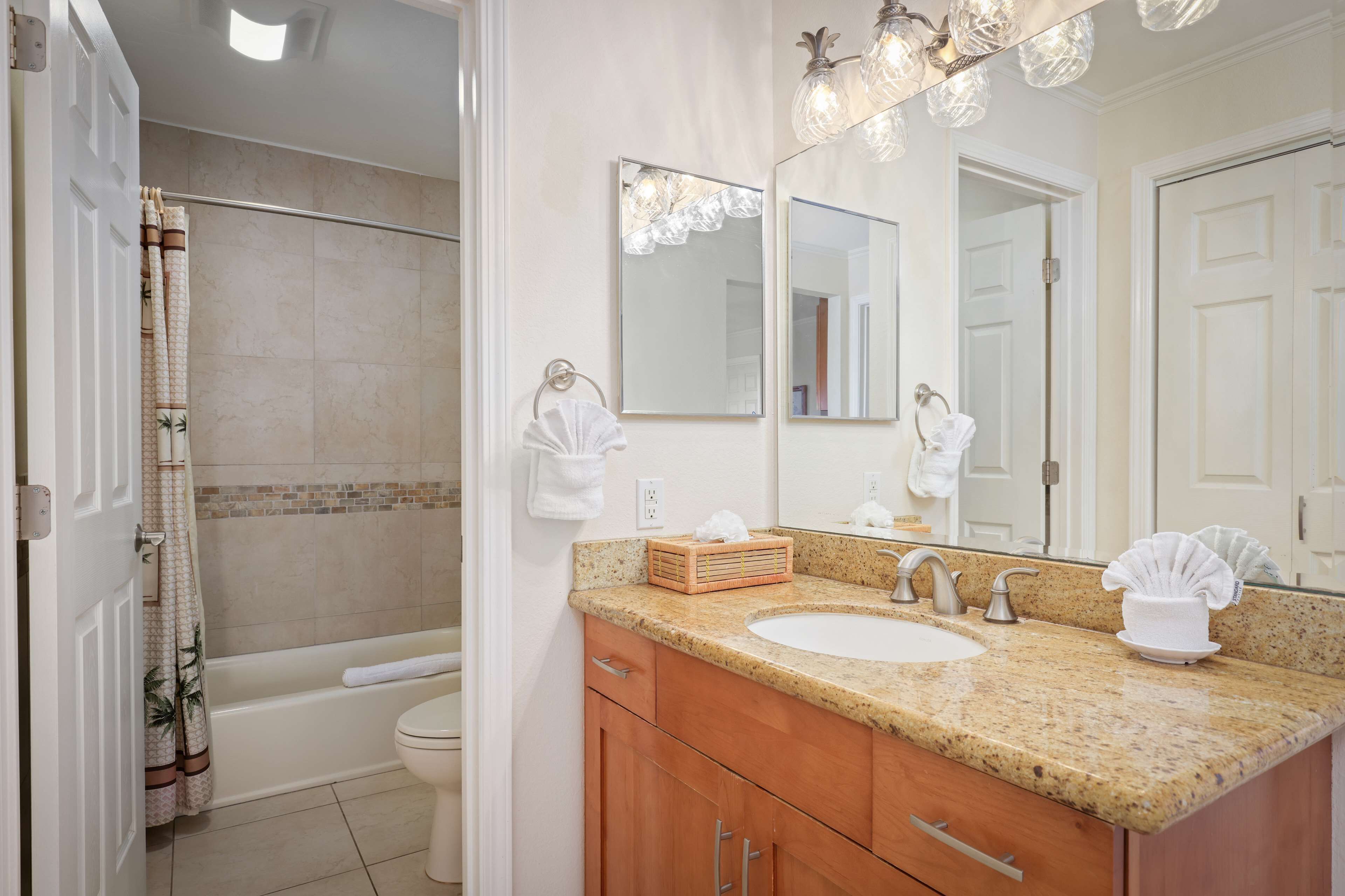 A bathroom with a bathtub, toilet, sink, and vanity.