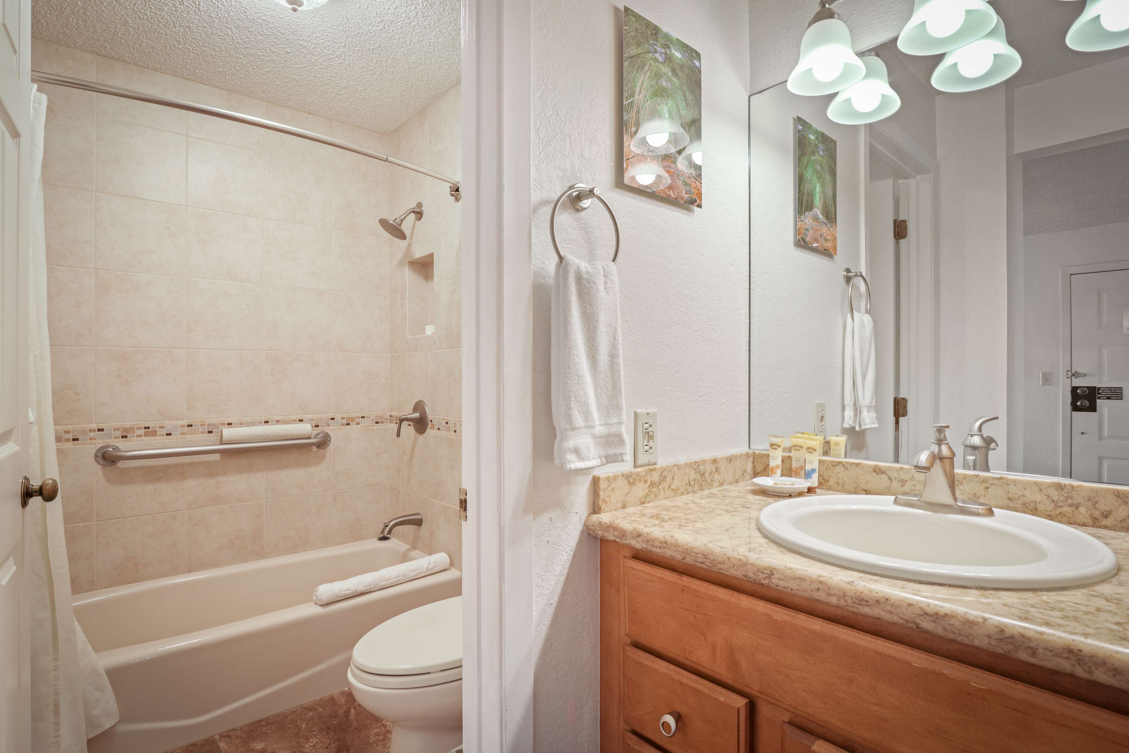 Un baño con bañera, inodoro, lavabo y espejo.