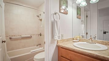 Un baño con bañera, inodoro, lavabo y espejo.