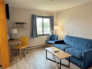 Suite, 1 cama King size, refrigerador y microondas | Área de sala de estar | Televisión LED de 42 pulgadas con canales por cable y televisión 