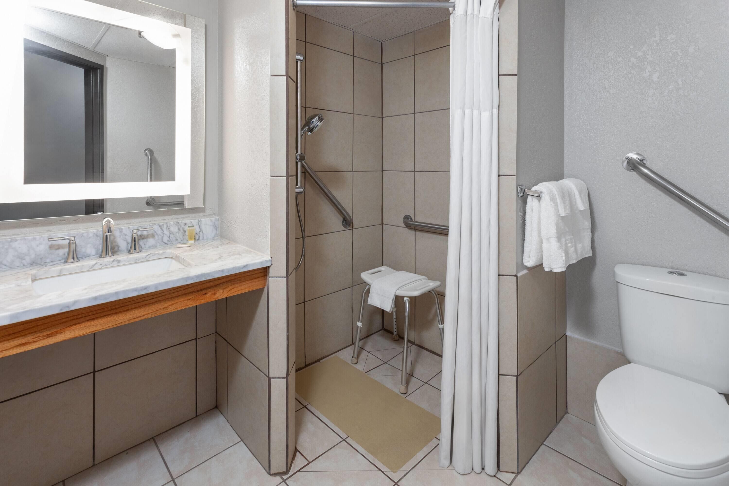 A modern bathroom with a shower, toilet, and sink.