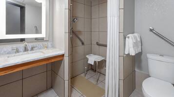 A modern bathroom with a shower, toilet, and sink.