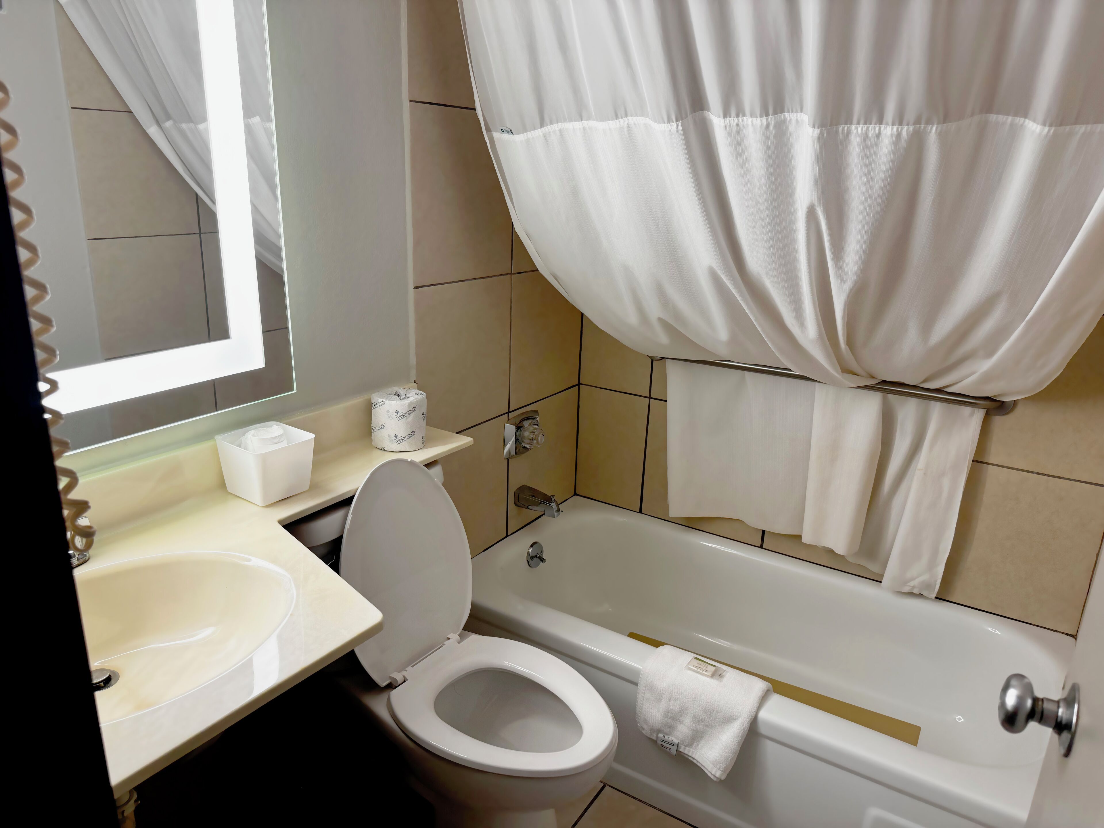 Un bagno con il water, un lavandino, una vasca e uno specchio.