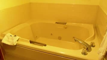 Une salle de bain d’hôtel standard, équipée d’une baignoire, d’une douche et de toilettes.
