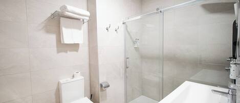 Un baño moderno con inodoro, bidé y ducha.