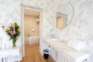 Bathroom features a vanity, sink, and toilet, with a shower area nearby.