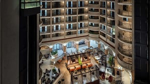 A multi-level hotel atrium with a central open space, multiple balconies, and a variety of seating areas. - Embassy Suites by Hilton Orlando North (Altamonte Springs)
