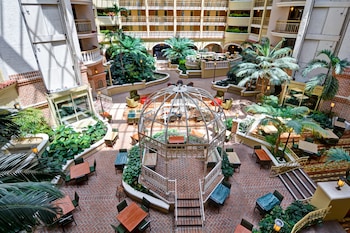 A multi-level hotel atrium with a central open space, multiple balconies, and a variety of seating areas. at Embassy Suites by Hilton Orlando North