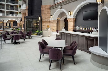 A spacious lobby with high ceilings, a chandelier, and a reception desk. at Embassy Suites by Hilton Orlando North