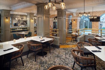 A hotel atrium with multiple floors, outdoor seating areas, and a central garden. at Embassy Suites by Hilton Orlando North