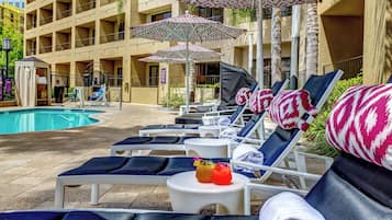 Una piscina al aire libre, camas de piscina gratis, sombrillas