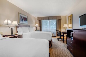 A hotel room with two beds, a desk, a chair, a dresser, a TV, and a window with curtains. - Clarion Inn Elmira-Horseheads (Elmira)