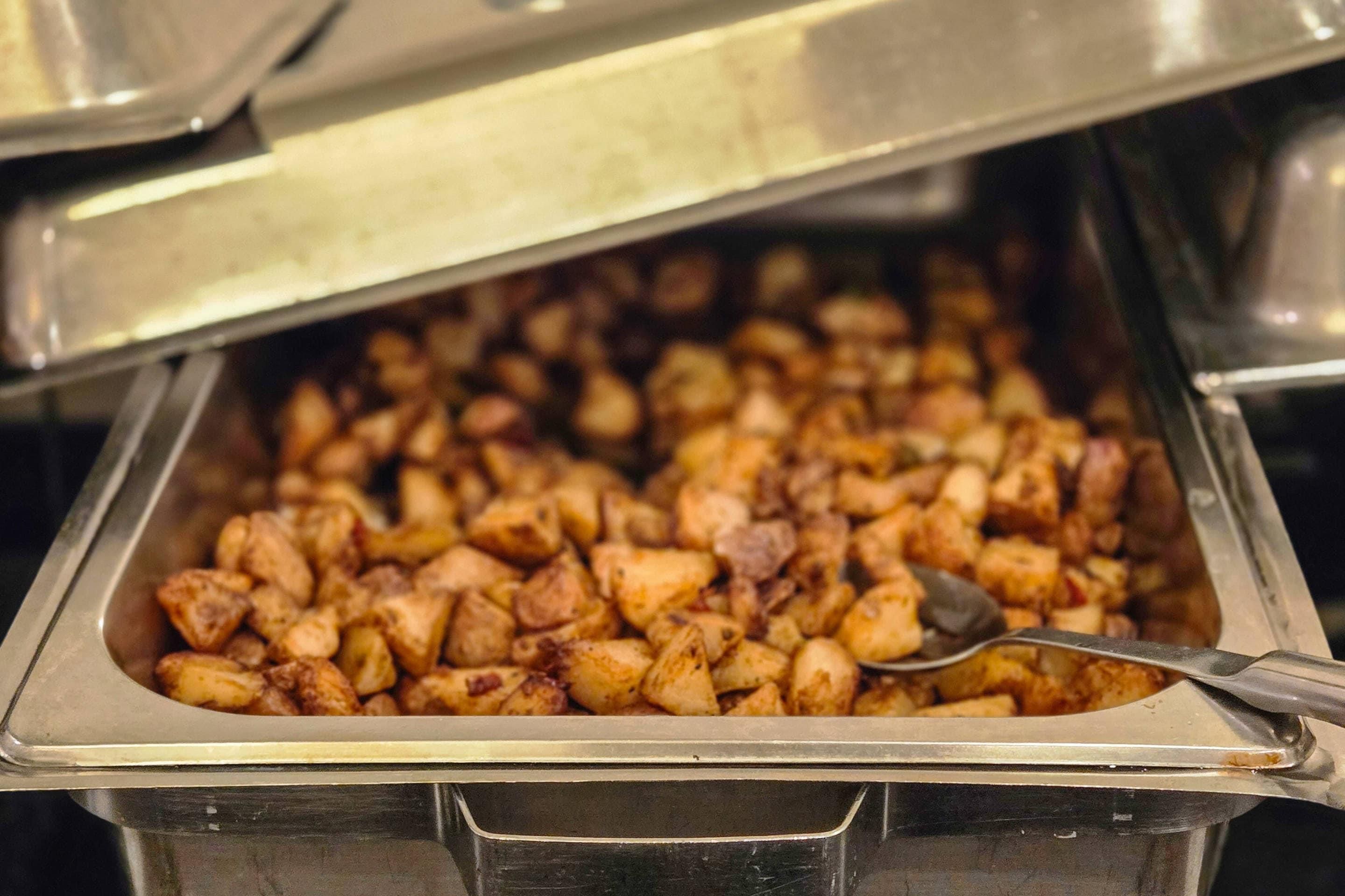 Un bufé con una variedad de comidas, incluyendo aparentemente patatas asadas y otros platos.