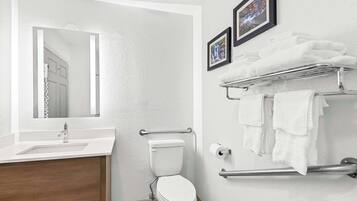 Un baño moderno con un lavabo blanco, un inodoro y un perchero para toallas.