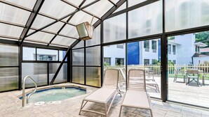 A glass-enclosed pool area with lounge chairs, a diving board, and a view of the outside. - Comfort Inn near Great Smoky Mountain National Park (Maggie Valley)