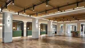 A spacious lobby with high ceilings, wooden flooring, and modern lighting fixtures. - Sheraton Birmingham Hotel (Birmingham)