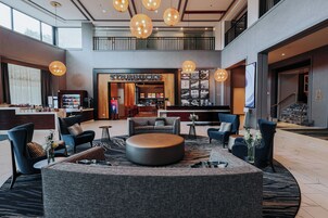 Un vestíbulo amplio con Starbucks, asientos cómodos y un diseño moderno.