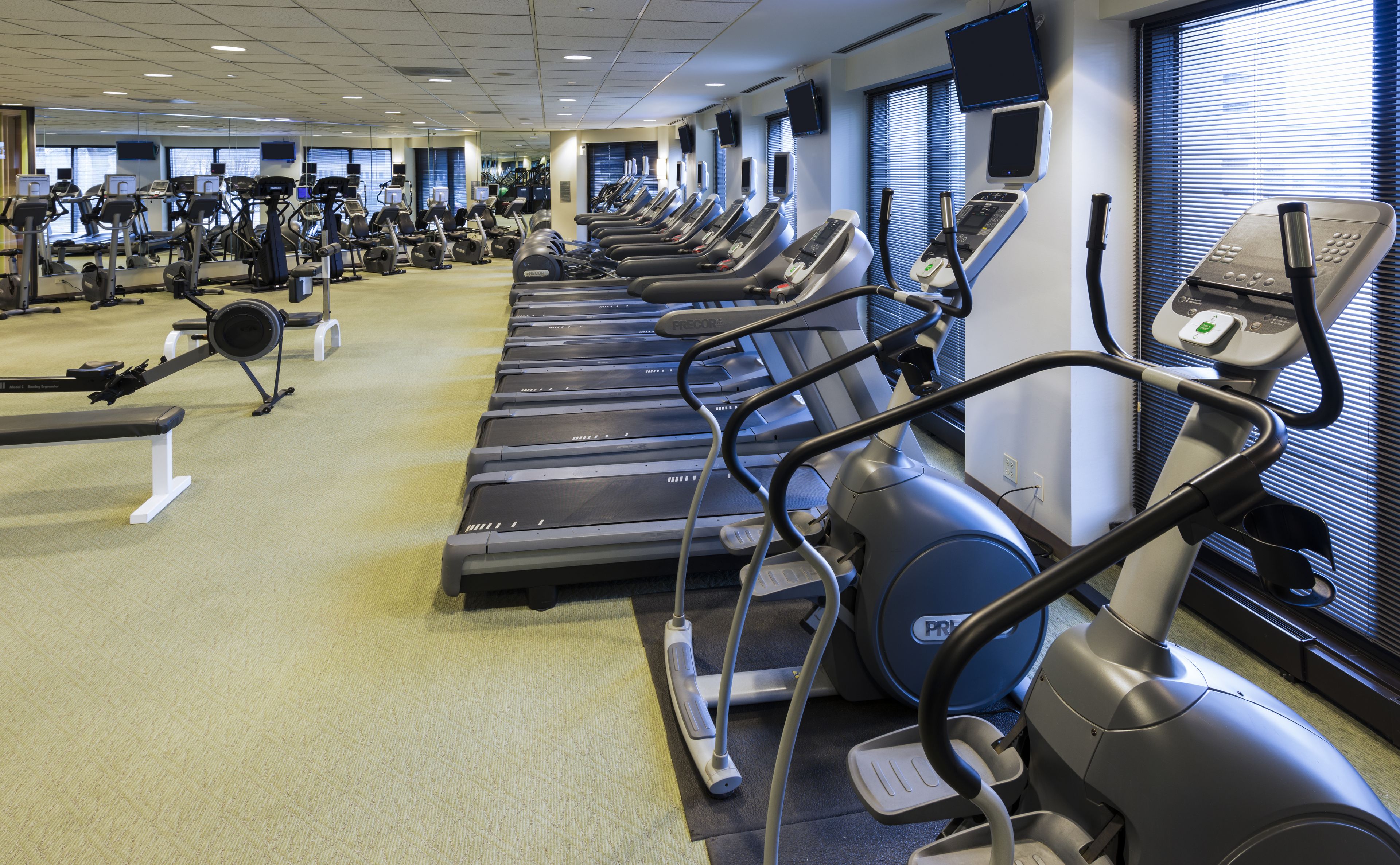 A gym with multiple treadmills, exercise bikes, and weight machines.