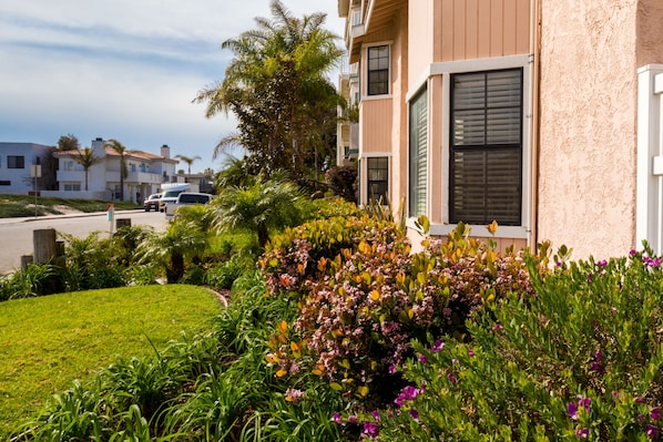 Un edificio residencial con un jardín bien cuidado al frente.