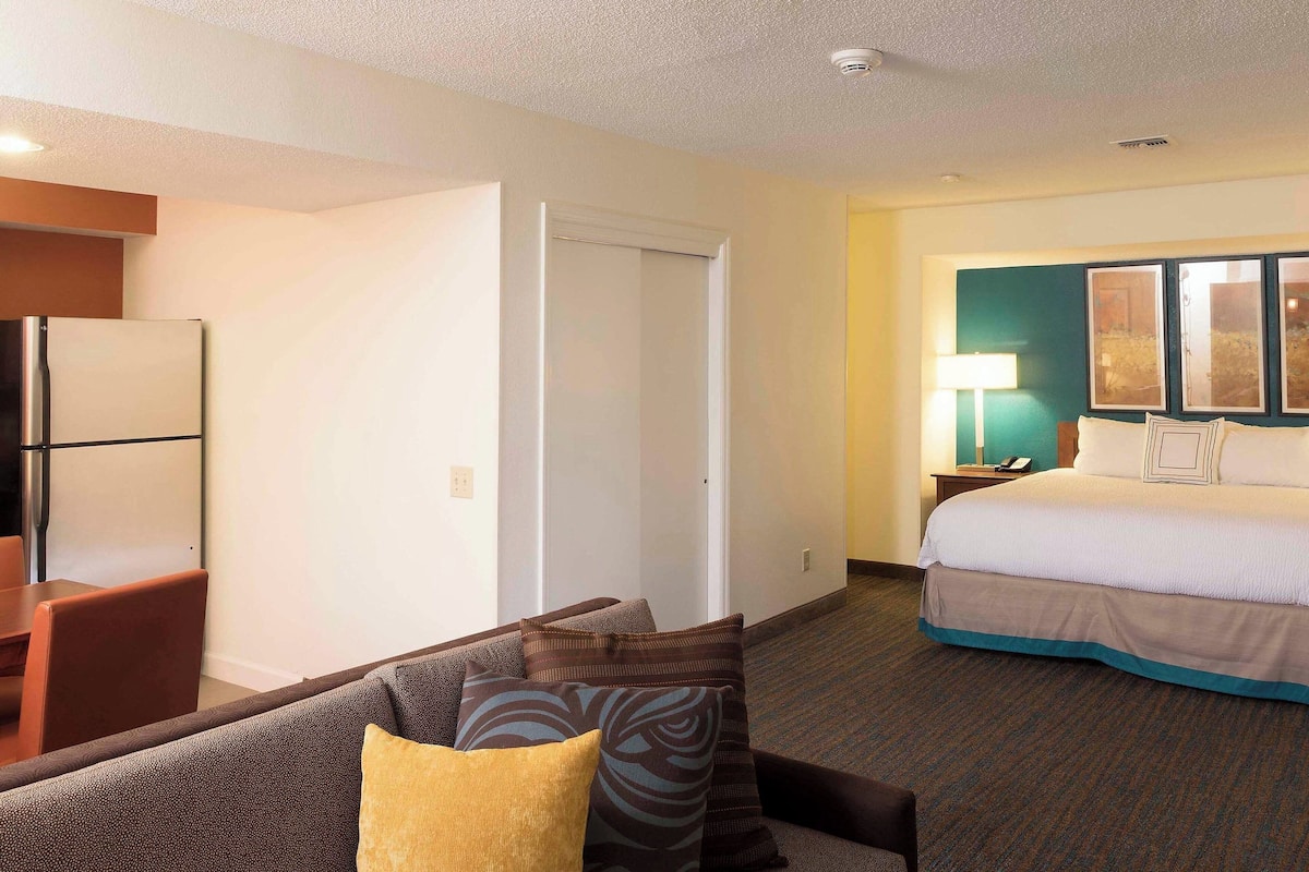 A hotel room with a bed, a desk, and a couch.