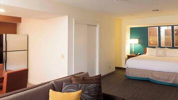 A hotel room with a bed, a desk, and a couch.