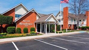 A Marriott Residence Inn with a brick facade, a covered entrance, and a flagpole with the American flag.
