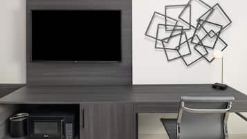 A modern office setup with a flat-screen TV, a microwave, and a desk chair.