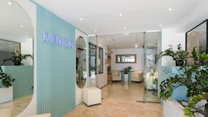 A modern reception area with a neon sign, glass doors, and a seating area with potted plants. - Best Western Hotel Mediterranee Menton (Menton)