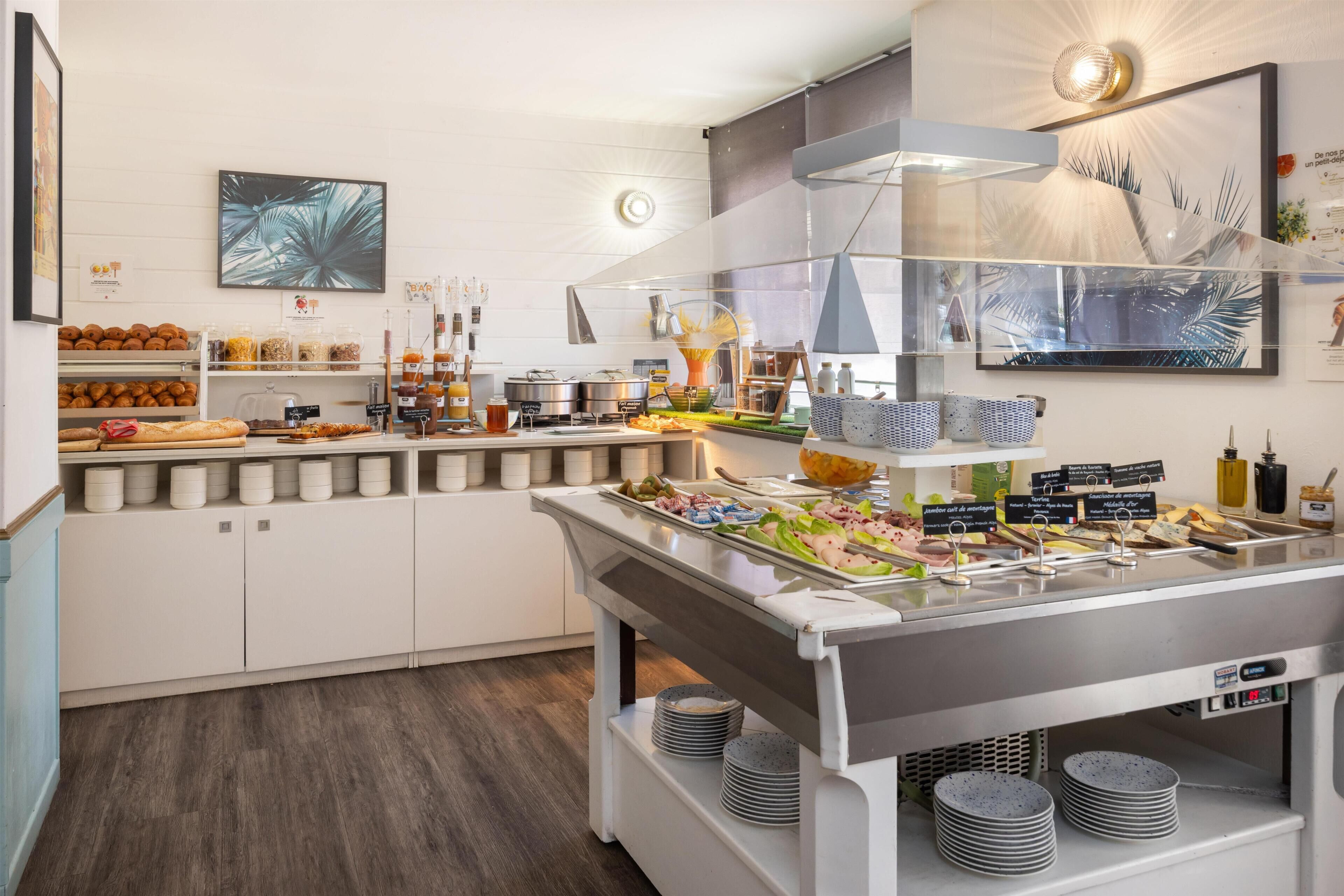 En buffet med forskellige retter, kaffestation og et køkkenområde.