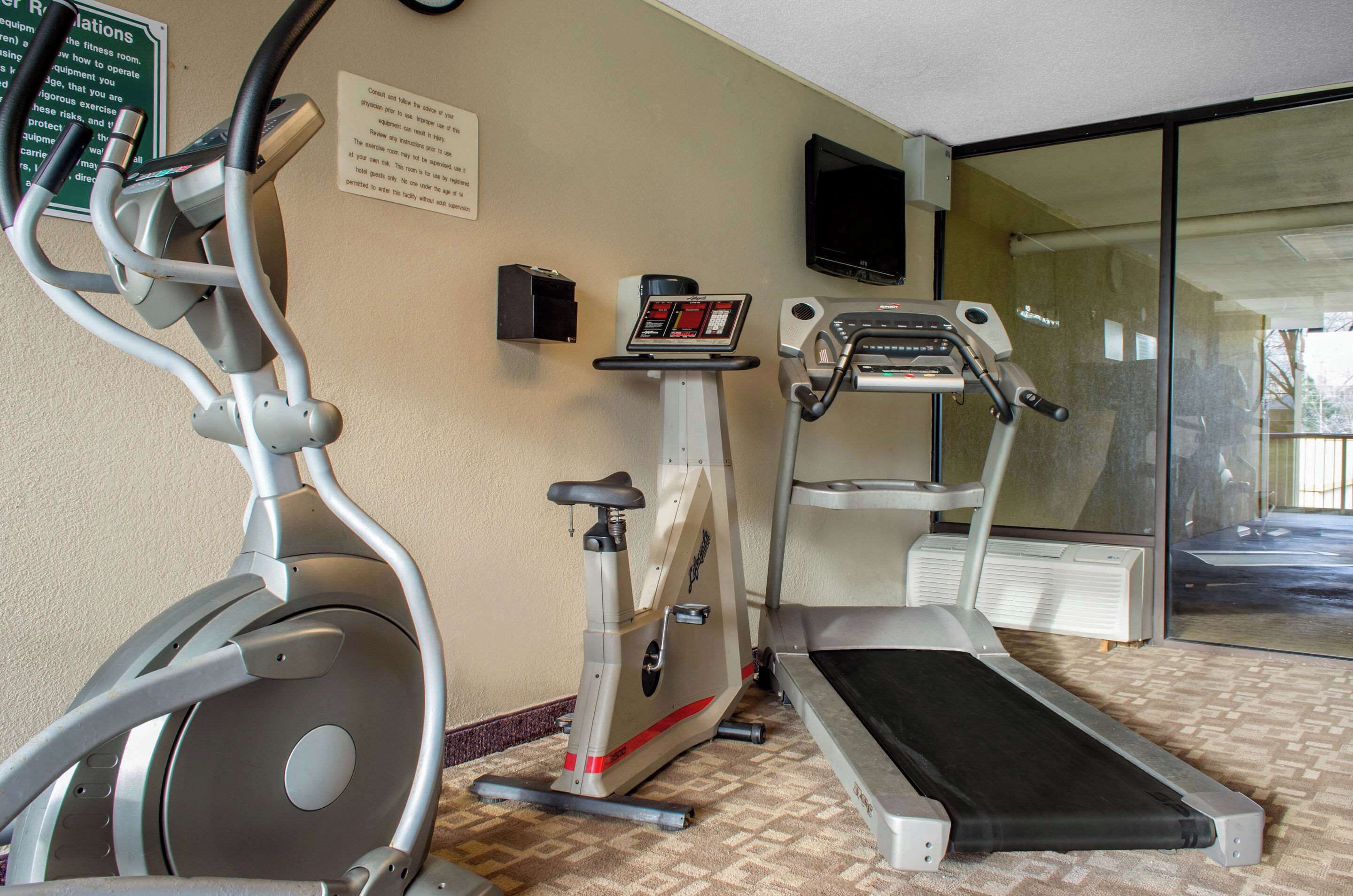 Una sala de fitness amb una cinta el·líptica, una bicicleta estatica i una cinta de córrer.