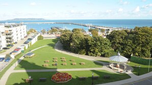 A park with benches, a gazebo, and a view of the sea and a bridge. - The Royal Marine Hotel (Dublin)