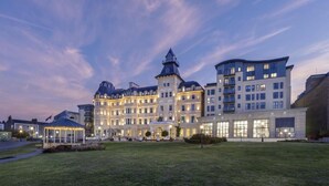 A large, historic hotel with a central tower and multiple wings, featuring a well-maintained lawn and a gazebo. - The Royal Marine Hotel (Dublin)