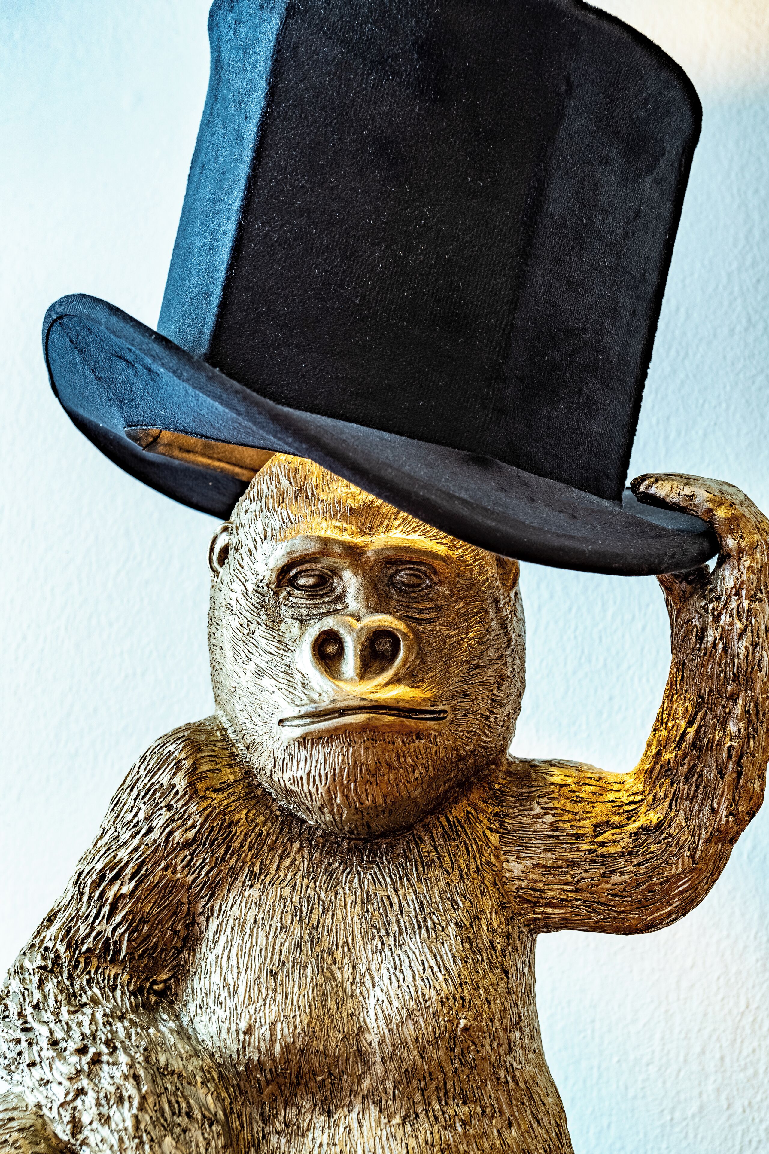 A gorilla statue wearing a top hat.