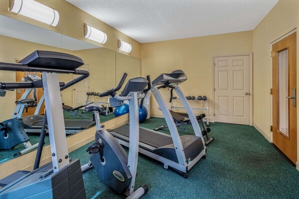 A gym with treadmills, elliptical machines, and free weights.