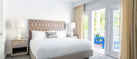 A hotel room with a large bed, two bedside tables with lamps, a wooden headboard, and a view of the outdoors through a sliding glass door.