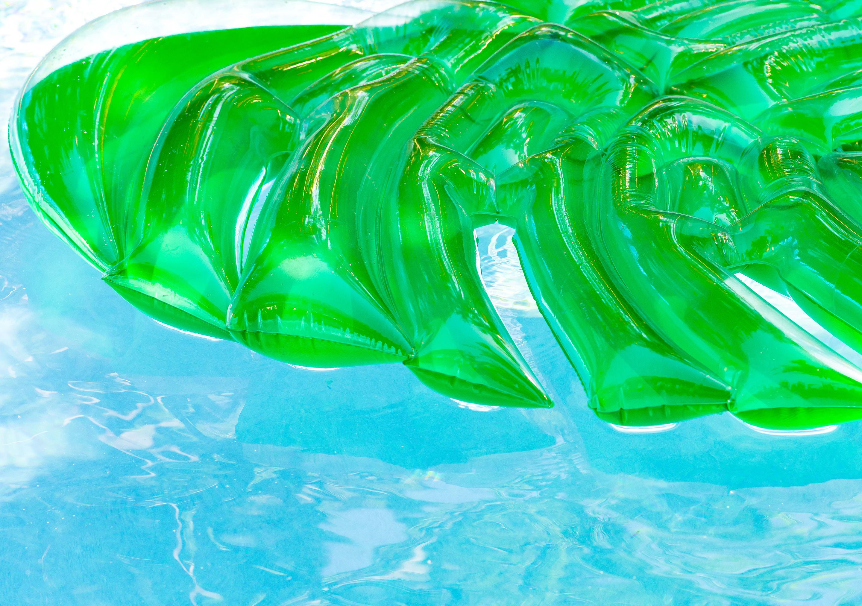 A clear view of a pool with inflatable green leaf-shaped floats.