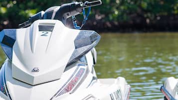 Un jet ski con el número 2 en la parte frontal, agua de fondo y una correa azul unida a la manija.