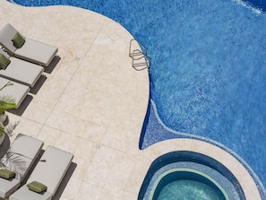 A swimming pool with a tiled deck, lounge chairs, and a hot tub. - The Brighton Hotel Sydney - MGallery Collection (Brighton-le-Sands)